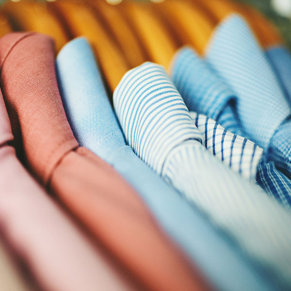 Assortment of mens shirts on wooden coat hangers